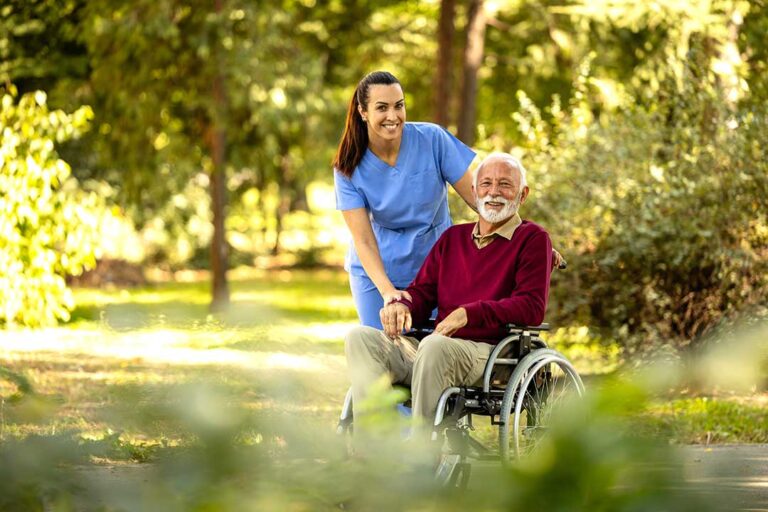 An older adult discusses care preferences with a family member at a kitchen table, documents spread out before them.