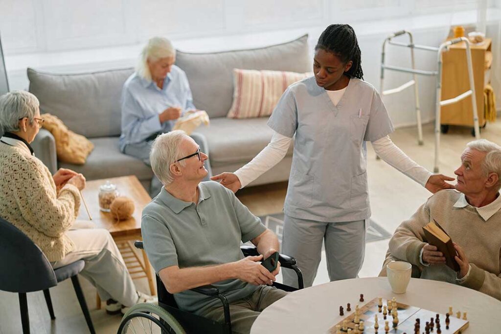 Staff guide older adults through a well-lit assisted living hallway during an emergency preparedness drill.